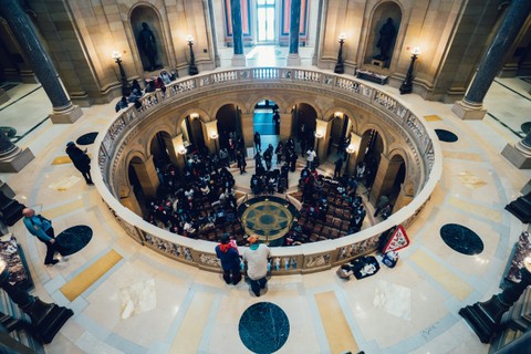 A birds eye view of the inside of a federal building, with people walking around a circular floor.